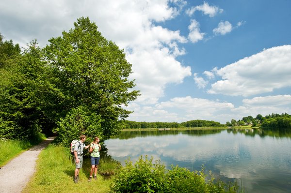 Zwei Personen genießen die Natur an einem ruhigen See