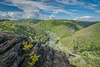 Blick auf grüne Hügel und ein kleines Dorf in der Ferne