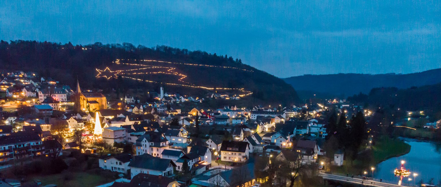 Lichterglanz und Weihnachtsdekoration in einer Stadt am Fluss