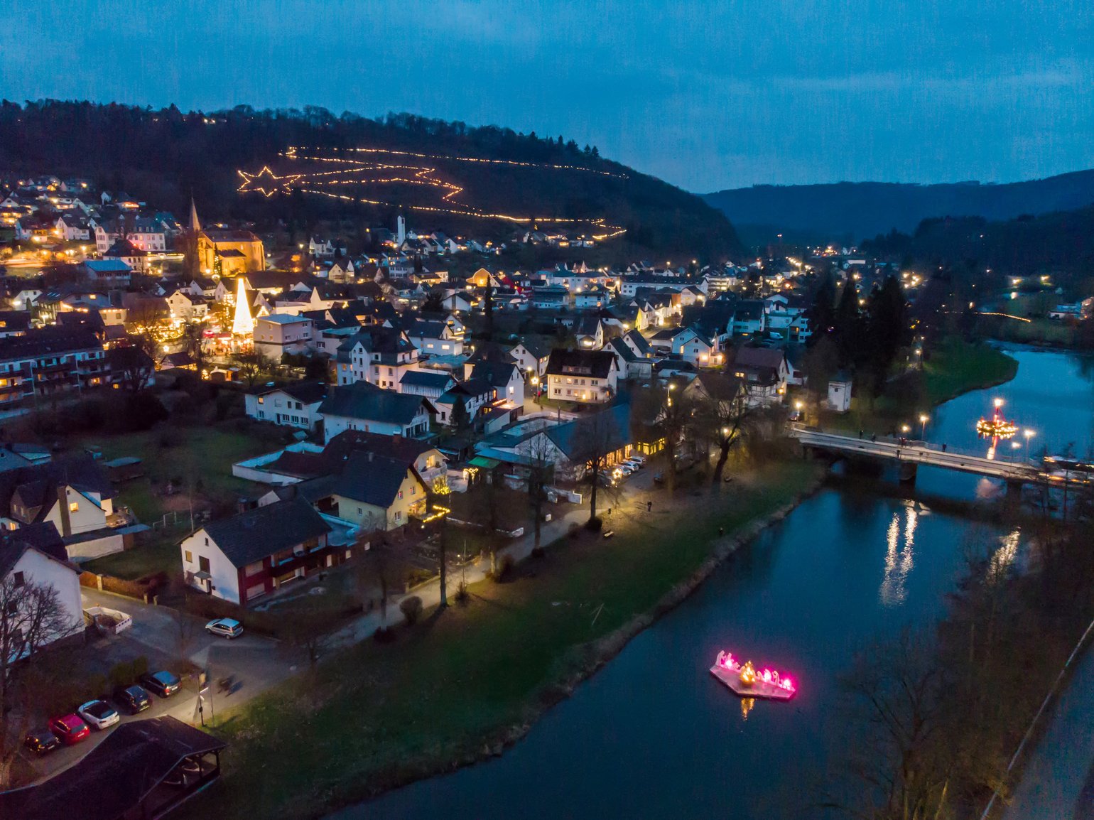 Lichterglanz und Weihnachtsdekoration in einer Stadt am Fluss