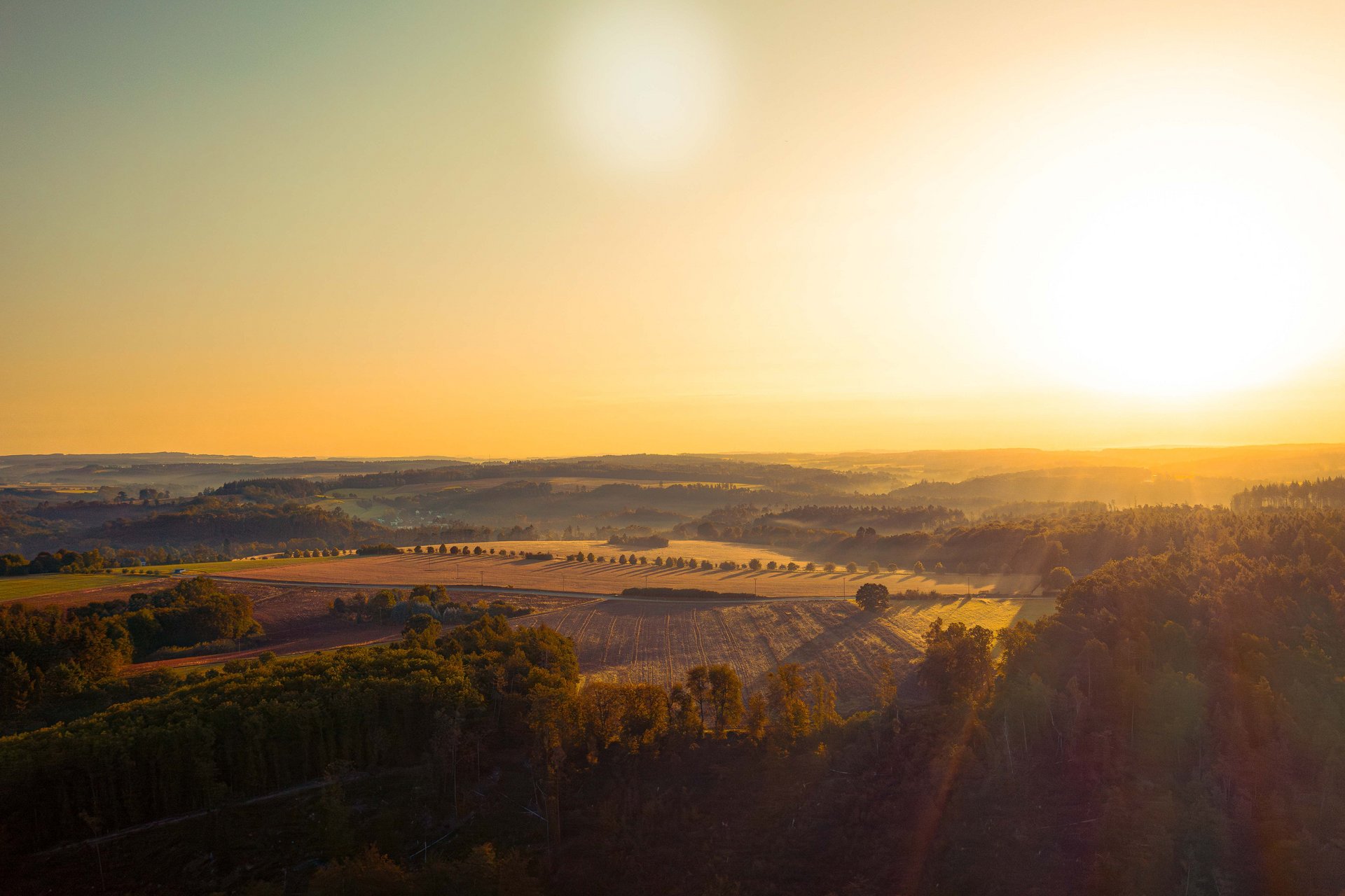 Blick auf die Felder und Wälder bei Sonnenuntergang