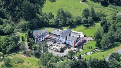 Ein Hotel umgeben von Grünflächen und Bäumen in einer ländlichen Gegend