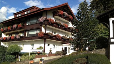 Fassade eines Hotels mit blühenden Balkonpflanzen und gepflegtem Umfeld