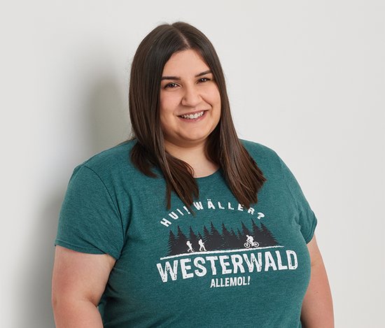 Frau in einem grünen T-Shirt mit dem Aufdruck 'Westerwald' lächelt freundlich