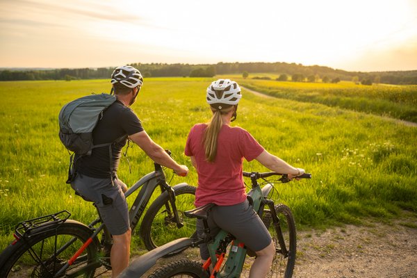 Radfahrer genießen den Sonnenuntergang in einer grünen Landschaft