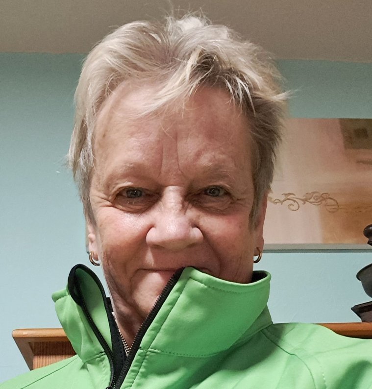 Silvia Patt mit grüner Jacke, die ihren Namen und Titel zeigt.