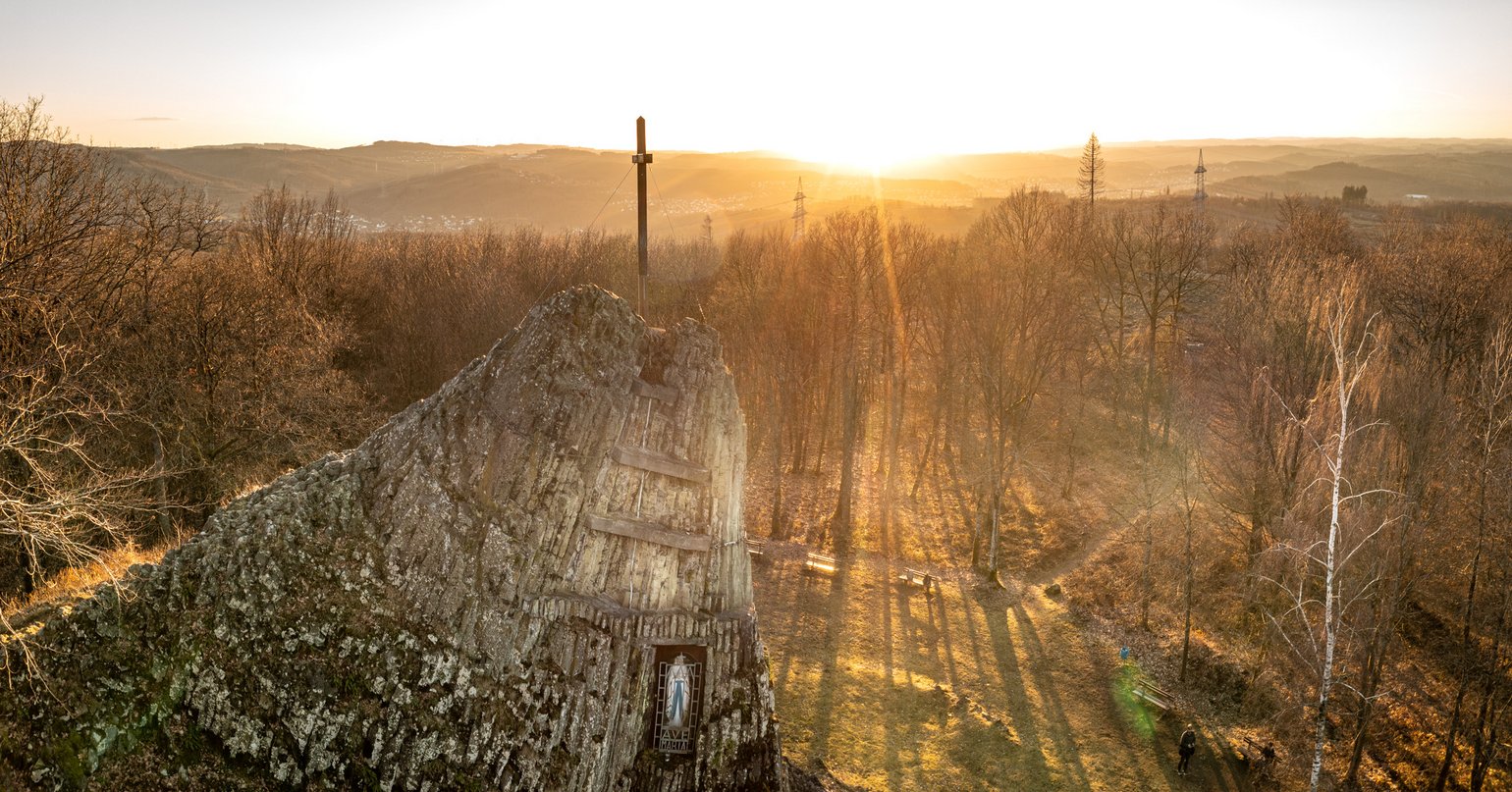 Scenic view of a rocky structure at sunset with forested landscape