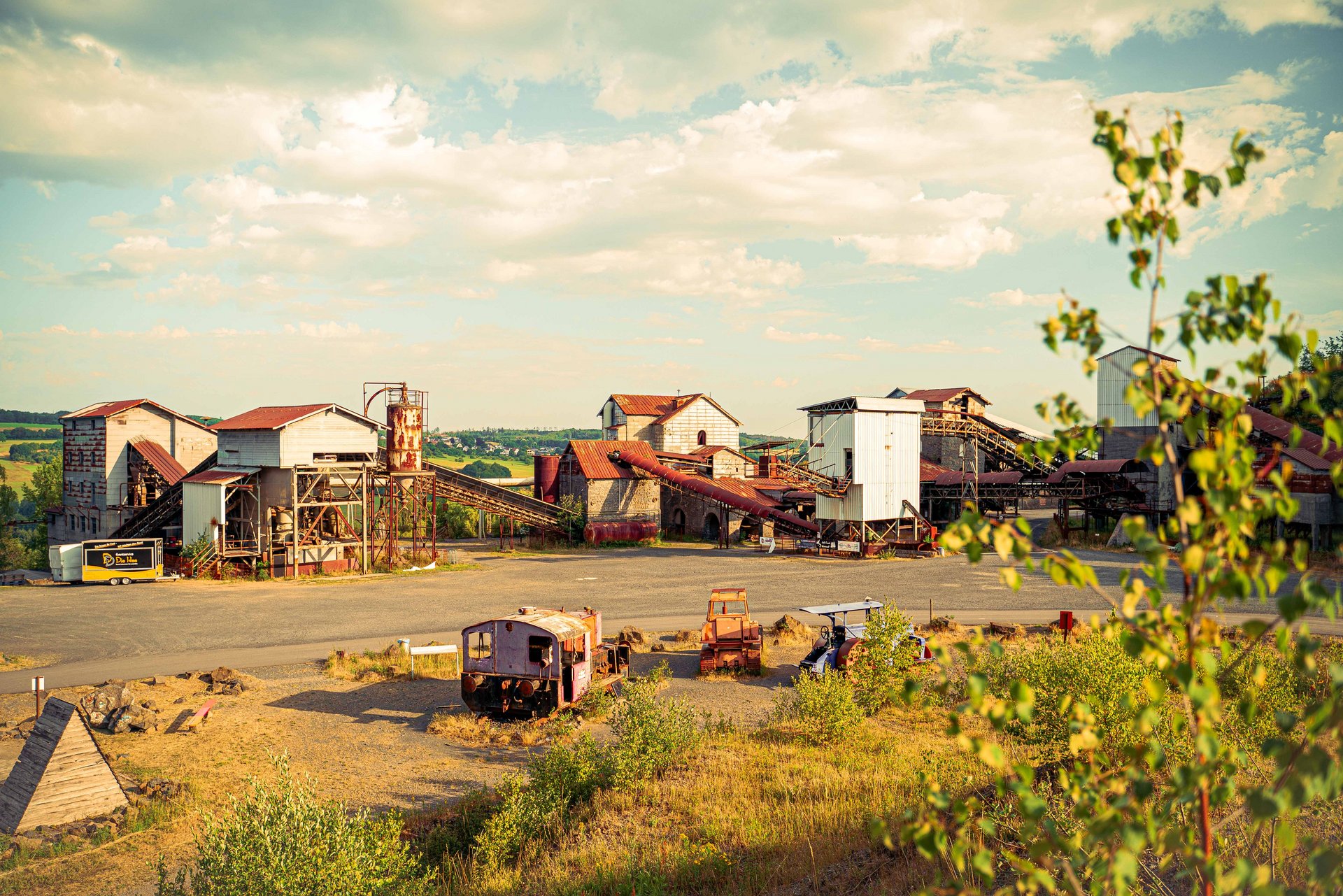 Alte Fabrikgebäude und Fahrzeuge in einer Landschaft
