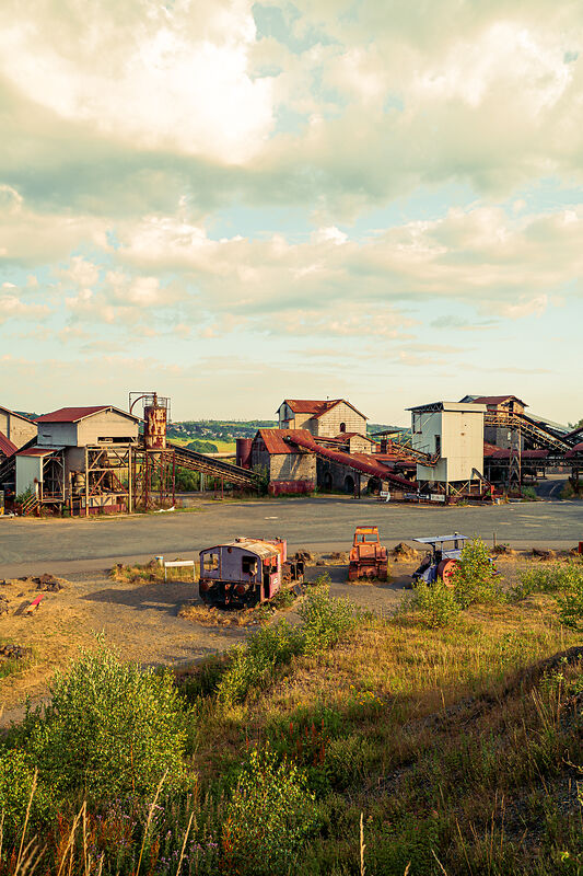 Ruine einer ehemaligen Industrieanlage mit alten Fahrzeugen und Maschinen