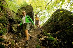 Wanderer zwischen Felsen am Naturpfad Weltende