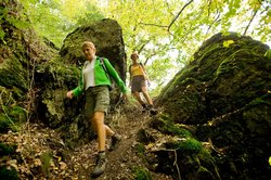 Wanderer zwischen Felsen am Naturpfad Weltende