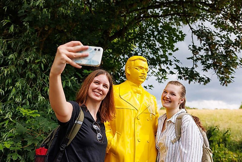 Wanderinnen machen Selfie mit einer Raiffeisenfigur